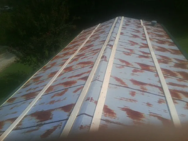 Rusted metal roof panels with new wood purlins before replacement — Storm Damage Roof Repair in Lutts by Roofing Brothers