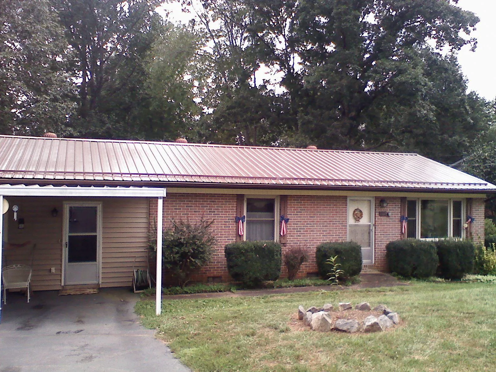 Bronze metal roof and carport on a brick ranch home — Roof Repair work by our crew in Lutts
